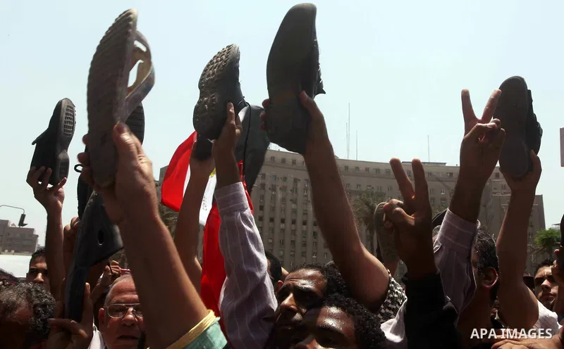 Egyptian protesters hold shoes and shout slogans against the presidential candidate Ahmed Shafik, during a protest in Tahrir Square, Cairo, Egypt, 01 June 2012. Media reports state that hundreds of Egyptians held a demon...