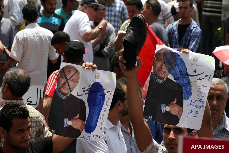 Egyptian protesters hold placards and shout slogans against the presidential candidate Ahmed Shafik, during a protest in Tahrir Square, Cairo, Egypt, 01 June 2012. Media reports state that hundreds of Egyptians held a de...