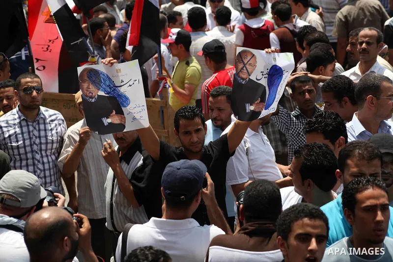 Egyptian protesters hold placards and shout slogans against the presidential candidate Ahmed Shafik, during a protest in Tahrir Square, Cairo, Egypt, 01 June 2012. Media reports state that hundreds of Egyptians held a de...