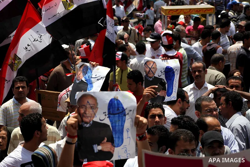 Egyptian protesters hold placards and shout slogans against the presidential candidate Ahmed Shafik, during a protest in Tahrir Square, Cairo, Egypt, 01 June 2012. Media reports state that hundreds of Egyptians held a de...