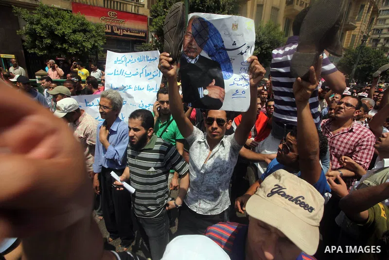 Egyptian protesters hold placards and shout slogans against the presidential candidate Ahmed Shafik, during a protest in Tahrir Square, Cairo, Egypt, 01 June 2012. Media reports state that hundreds of Egyptians held a de...