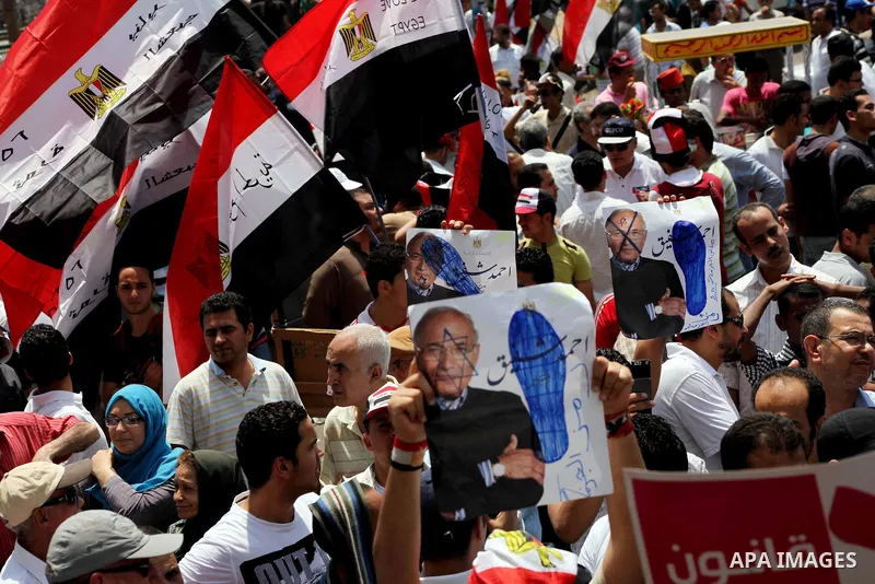 Egyptian protesters hold placards and shout slogans against the presidential candidate Ahmed Shafik, during a protest in Tahrir Square, Cairo, Egypt, 01 June 2012. Media reports state that hundreds of Egyptians held a de...