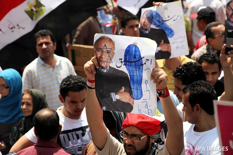 Egyptian protesters hold placards and shout slogans against the presidential candidate Ahmed Shafik, during a protest in Tahrir Square, Cairo, Egypt, 01 June 2012. Media reports state that hundreds of Egyptians held a de...