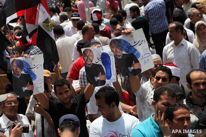 Egyptian protesters hold placards and shout slogans against the presidential candidate Ahmed Shafik, during a protest in Tahrir Square, Cairo, Egypt, 01 June 2012. Media reports state that hundreds of Egyptians held a de...