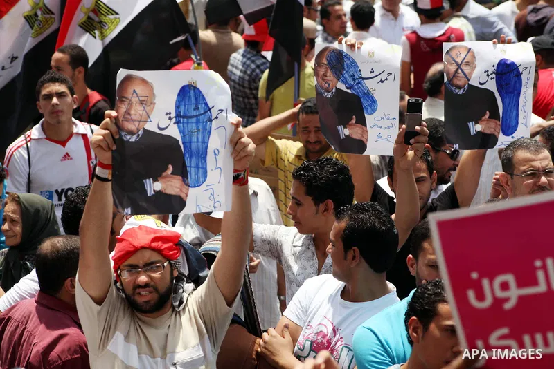 Egyptian protesters hold placards and shout slogans against the presidential candidate Ahmed Shafik, during a protest in Tahrir Square, Cairo, Egypt, 01 June 2012. Media reports state that hundreds of Egyptians held a de...