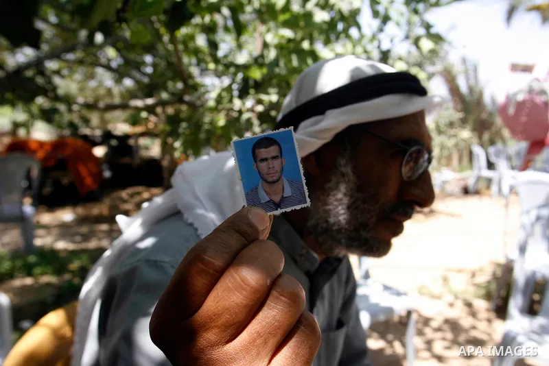 A relative of Ahmed Abu Nasr shows his photograph at his home in Khan Younis Refugee Camp, Friday, June 1, 2012. Abu Nasr and an Israeli soldier were killed in a shootout near the border with the Gaza Strip early Friday,...