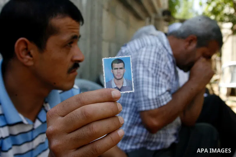 A relative of Ahmed Abu Nasr shows his photograph at his home in Khan Younis Refugee Camp, Friday, June 1, 2012. Abu Nasr and an Israeli soldier were killed in a shootout near the border with the Gaza Strip early Friday,...