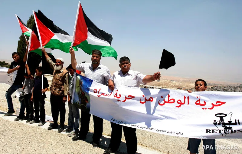 Palestinians hold national flag and shout slogans during a protest against continuing of 'Judaization of Jerusalem' by Jewish settlers and confiscating Palestinian lands at Al Tur and Damascus gate after Friday prayer in...