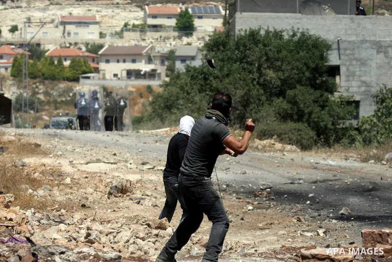 Palestinian protesters hurl a stones at Israeli soldiers during a demonstration against the expropriation of Palestinian land by Israel in the village of Kafr Qaddum, near the West Bank city of Nablus on June 1, 2012. Ph...