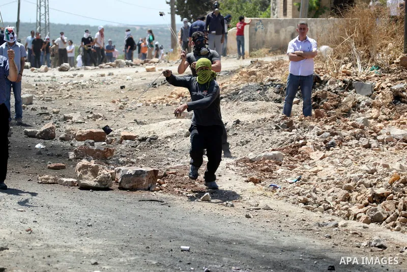 Palestinian protesters hurl a stones at Israeli soldiers during a demonstration against the expropriation of Palestinian land by Israel in the village of Kafr Qaddum, near the West Bank city of Nablus on June 1, 2012. Ph...