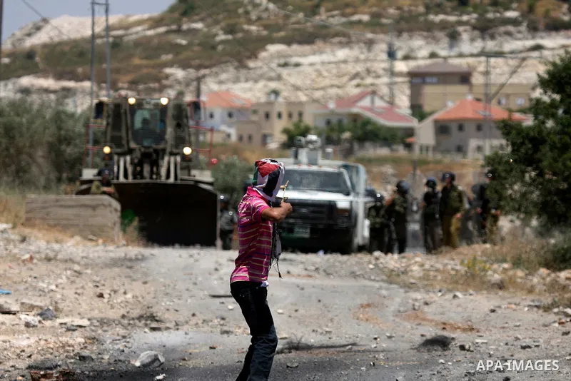 Palestinian protesters hurl a stones at Israeli soldiers during a demonstration against the expropriation of Palestinian land by Israel in the village of Kafr Qaddum, near the West Bank city of Nablus on June 1, 2012. Ph...