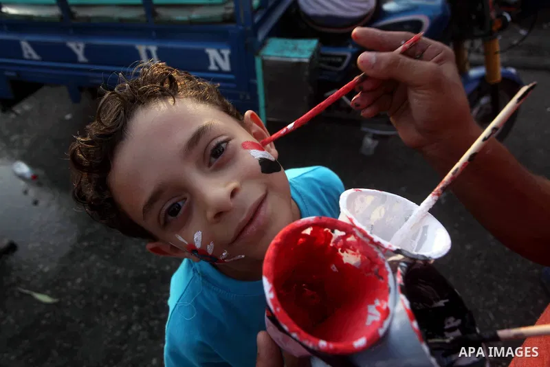 An Egyptian child draws national flag on face during a demonstration against Egyptian presidential candidate Ahmed Shafiq in Tahrir Square decrying the result of the first round of voting in the Egyptian presidential ele...