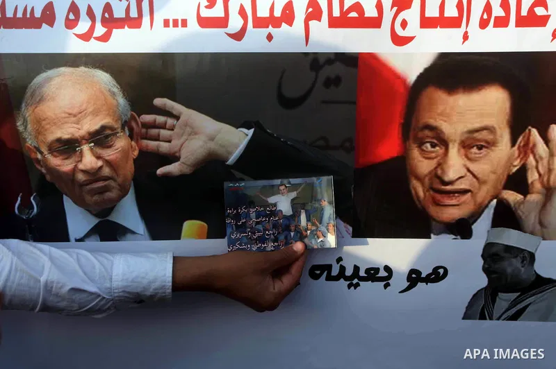 Egyptian protesters hold placards against the presidential candidate Ahmed Shafik during a demonstration in Tahrir Square decrying the result of the first round of voting in the Egyptian presidential election in Cairo, E...