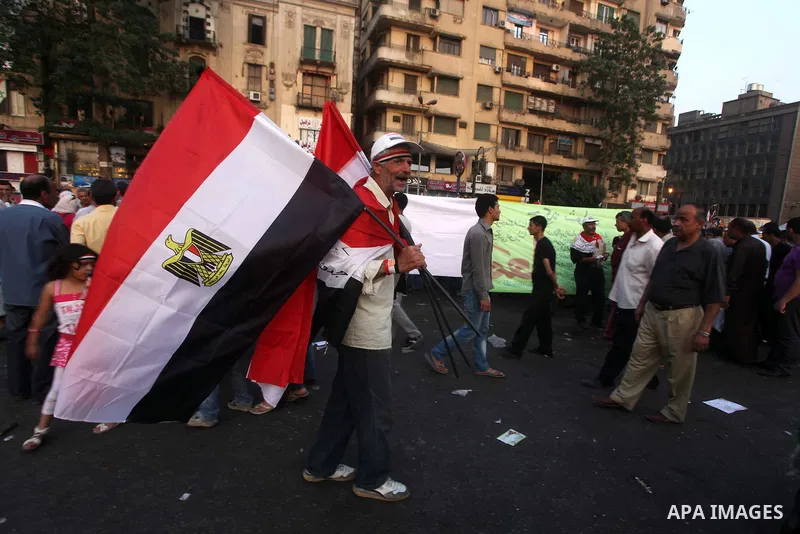 Egyptian protesters hold national flag during a demonstration against Egyptian presidential candidate Ahmed Shafiq in Tahrir Square decrying the result of the first round of voting in the Egyptian presidential election i...