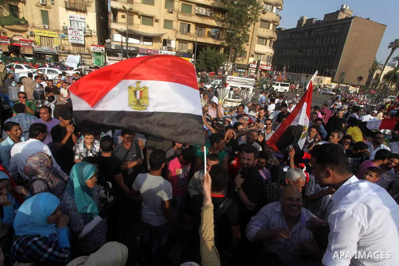 Egyptian protesters hold national flag during a demonstration against Egyptian presidential candidate Ahmed Shafiq in Tahrir Square decrying the result of the first round of voting in the Egyptian presidential election i...