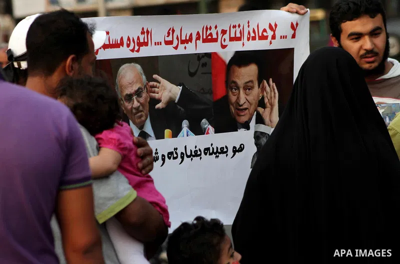 Egyptian protesters hold placards against the presidential candidate Ahmed Shafik during a demonstration in Tahrir Square decrying the result of the first round of voting in the Egyptian presidential election in Cairo, E...
