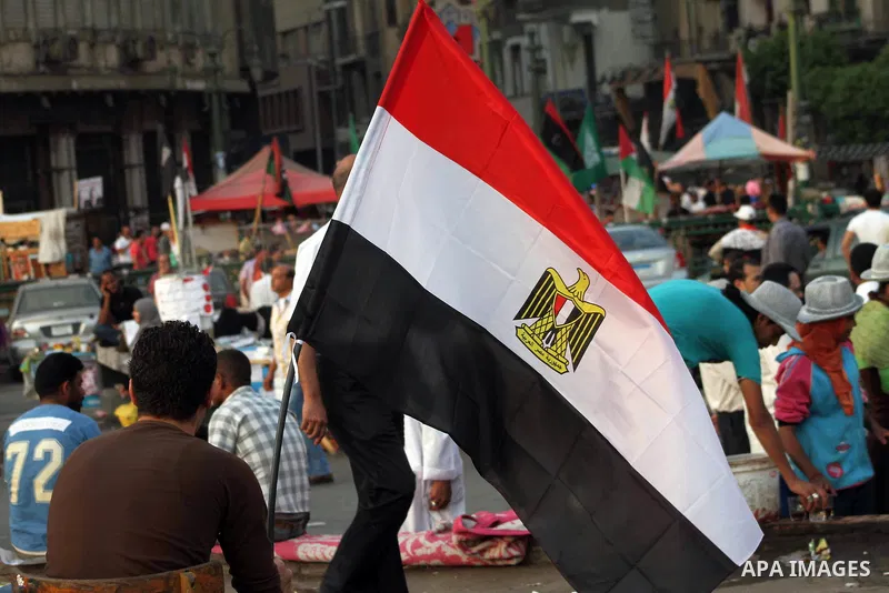Egyptian protesters hold national flag during a demonstration against Egyptian presidential candidate Ahmed Shafiq in Tahrir Square decrying the result of the first round of voting in the Egyptian presidential election i...