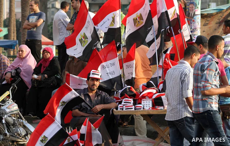 Egyptian protesters hold national flag during a demonstration against Egyptian presidential candidate Ahmed Shafiq in Tahrir Square decrying the result of the first round of voting in the Egyptian presidential election i...