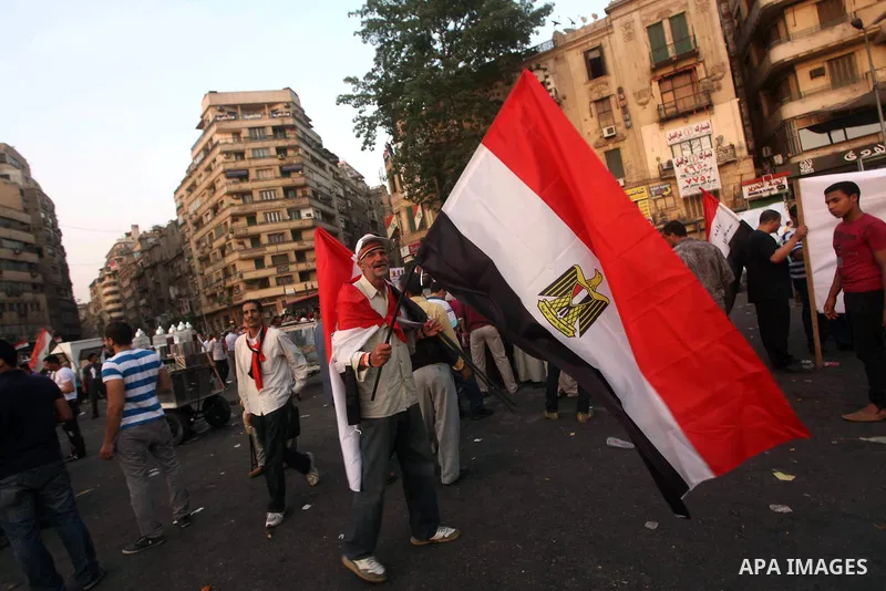 Egyptian protesters hold national flag during a demonstration against Egyptian presidential candidate Ahmed Shafiq in Tahrir Square decrying the result of the first round of voting in the Egyptian presidential election i...