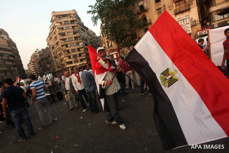 Egyptian protesters hold national flag during a demonstration against Egyptian presidential candidate Ahmed Shafiq in Tahrir Square decrying the result of the first round of voting in the Egyptian presidential election i...