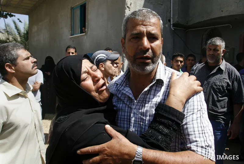 The mother of Palestinian militant Ahmed Abu Nasser, 20, is comforted by relatives as she mourns during his funeral in Khan Yunis in the southern Gaza Strip on June 2, 2012. An Israeli soldier and two Palestinian militan...