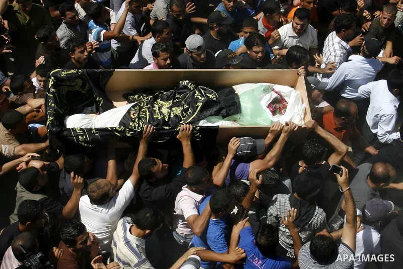 Palestinians carry a flag-covered coffin containing the body of gunman Ahmed Nassir in Khan Younis in the southern Gaza Strip June 2, 2012. Nassir broke into Israel on Friday and killed a soldier before being shot dead h...