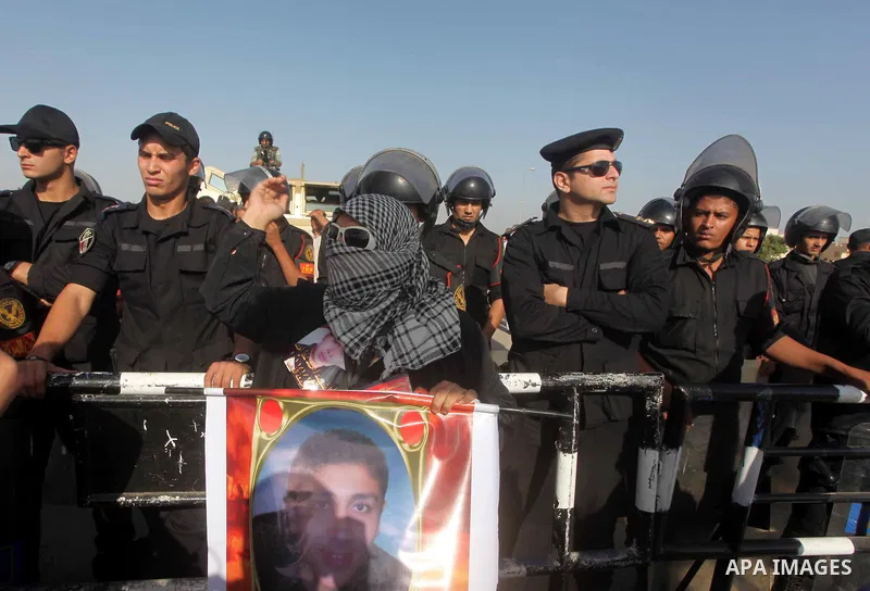 Egyptians Anti-Mubarak protester holding poster depicting youth killed during the uprising, reacts after a court sentenced deposed president Hosni Mubarak to life in prison, outside the police academy in Cairo, Egypt, 02...