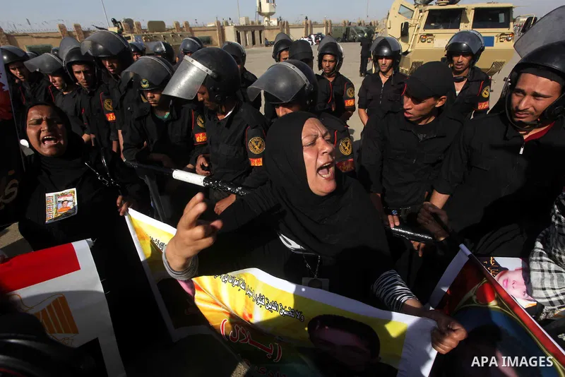 Egyptians Anti-Mubarak protester holding poster depicting youth killed during the uprising, reacts after a court sentenced deposed president Hosni Mubarak to life in prison, outside the police academy in Cairo, Egypt, 02...