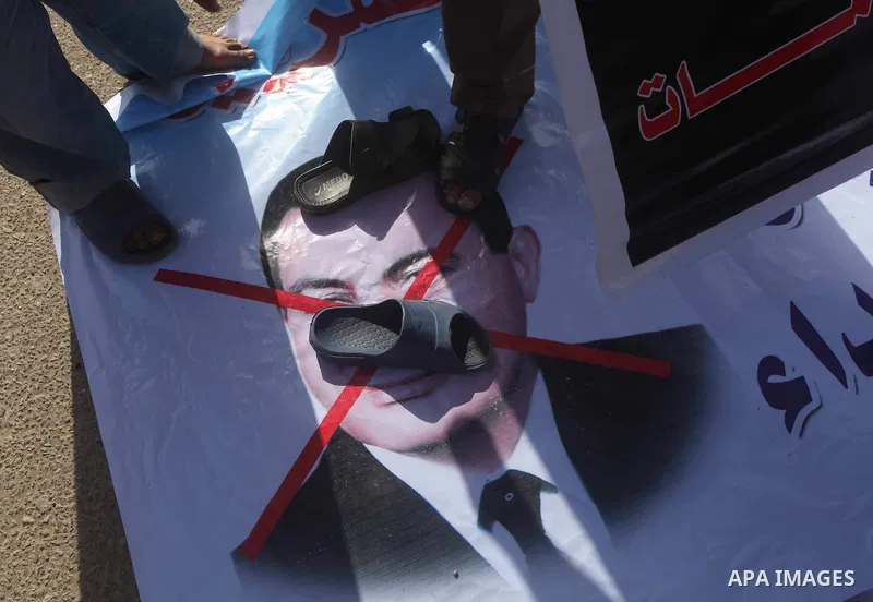 Egyptians Anti-Mubarak protester holding poster depicting youth killed during the uprising, reacts after a court sentenced deposed president Hosni Mubarak to life in prison, outside the police academy in Cairo, Egypt, 02...