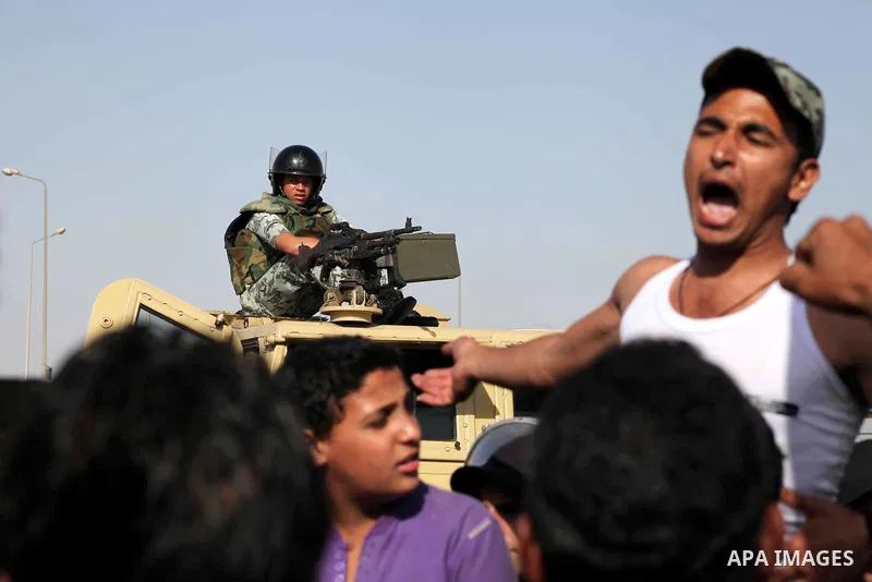 Egyptians Anti-Mubarak protester holding poster depicting youth killed during the uprising, reacts after a court sentenced deposed president Hosni Mubarak to life in prison, outside the police academy in Cairo, Egypt, 02...