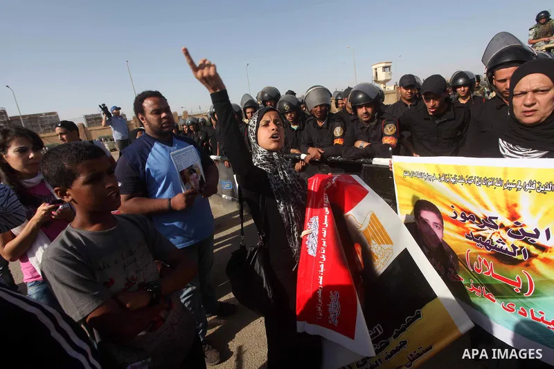 Egyptians Anti-Mubarak protester holding poster depicting youth killed during the uprising, reacts after a court sentenced deposed president Hosni Mubarak to life in prison, outside the police academy in Cairo, Egypt, 02...