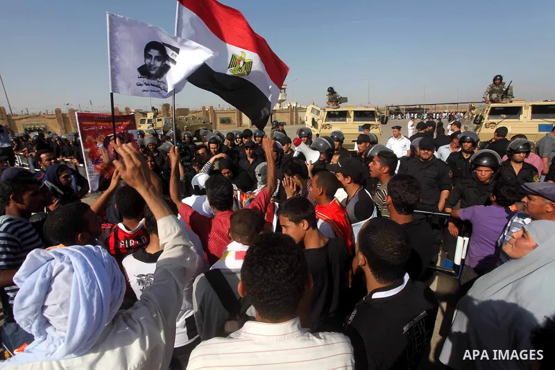 Egyptians Anti-Mubarak protester holding poster depicting youth killed during the uprising, reacts after a court sentenced deposed president Hosni Mubarak to life in prison, outside the police academy in Cairo, Egypt, 02...