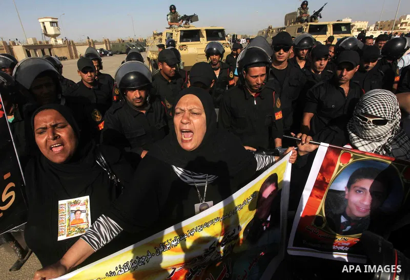Egyptians Anti-Mubarak protester holding poster depicting youth killed during the uprising, reacts after a court sentenced deposed president Hosni Mubarak to life in prison, outside the police academy in Cairo, Egypt, 02...
