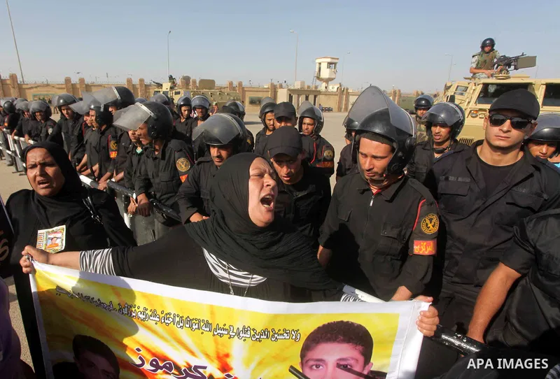 Egyptians Anti-Mubarak protester holding poster depicting youth killed during the uprising, reacts after a court sentenced deposed president Hosni Mubarak to life in prison, outside the police academy in Cairo, Egypt, 02...