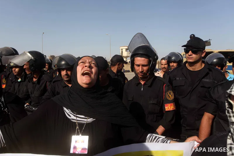 Egyptians Anti-Mubarak protester holding poster depicting youth killed during the uprising, reacts after a court sentenced deposed president Hosni Mubarak to life in prison, outside the police academy in Cairo, Egypt, 02...