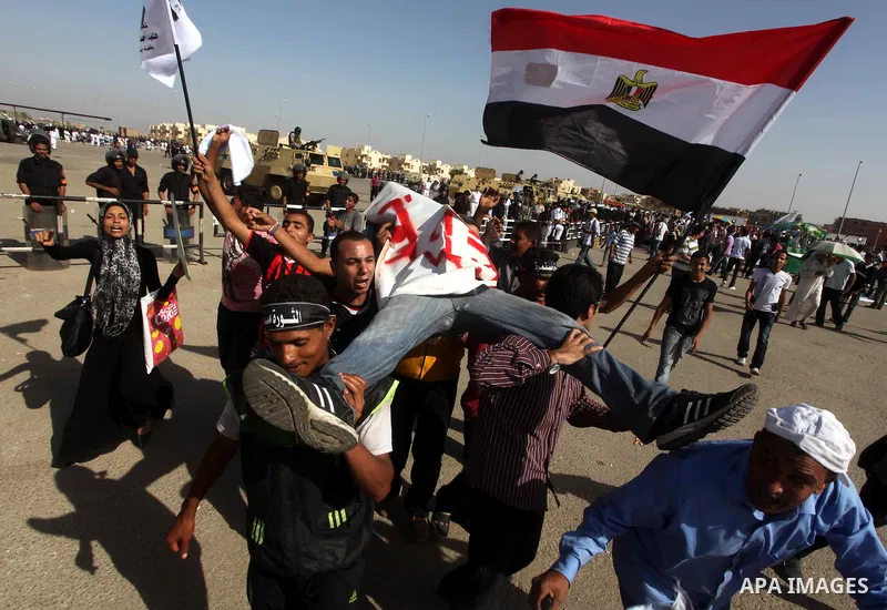 Egyptians Anti-Mubarak protester holding poster depicting youth killed during the uprising, reacts after a court sentenced deposed president Hosni Mubarak to life in prison, outside the police academy in Cairo, Egypt, 02...