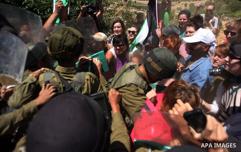 Israeli soldiers prevent Palestinians, left-wing Israeli and foreign peace activists from heading towards the Jewish settlement of Karim Tsor to protest against the confiscation of Palestinian land from the West Bank vil...