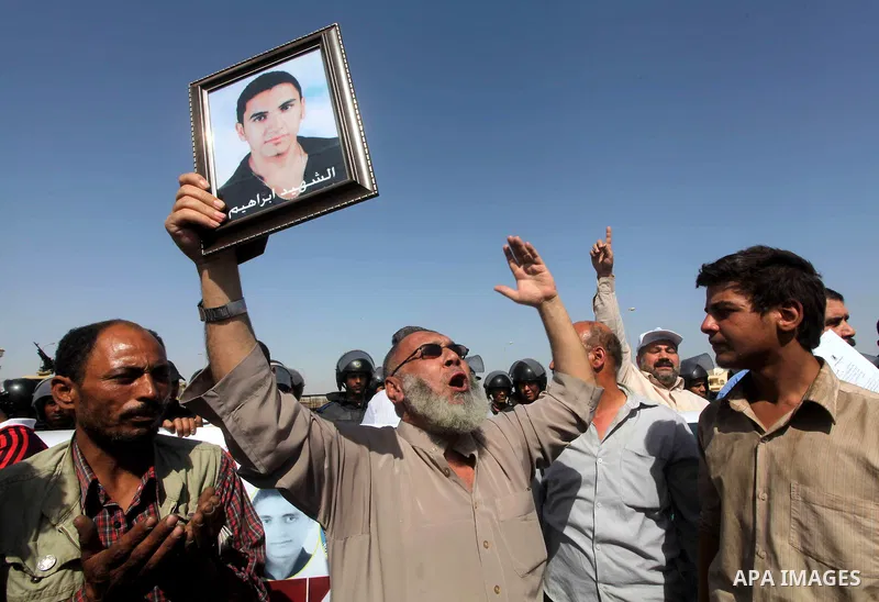 Egyptians Anti-Mubarak protester holding poster depicting youth killed during the uprising, reacts after a court sentenced deposed president Hosni Mubarak to life in prison, outside the police academy in Cairo, Egypt, 02...