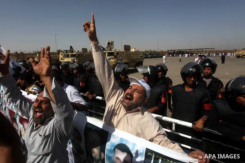 Egyptians Anti-Mubarak protester holding poster depicting youth killed during the uprising, reacts after a court sentenced deposed president Hosni Mubarak to life in prison, outside the police academy in Cairo, Egypt, 02...