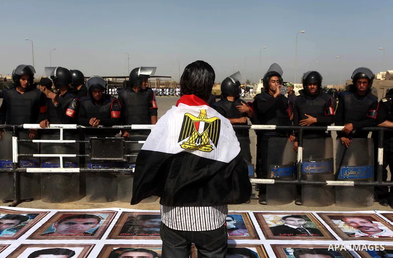Egyptians Anti-Mubarak protester holding poster depicting youth killed during the uprising, reacts after a court sentenced deposed president Hosni Mubarak to life in prison, outside the police academy in Cairo, Egypt, 02...