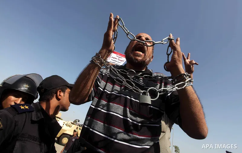 Egyptians Anti-Mubarak protester holding poster depicting youth killed during the uprising, reacts after a court sentenced deposed president Hosni Mubarak to life in prison, outside the police academy in Cairo, Egypt, 02...