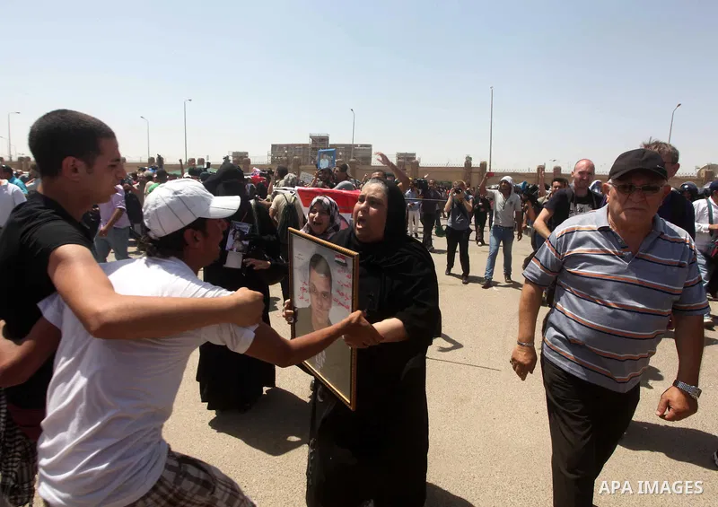 Egyptians Anti-Mubarak protester holding poster depicting youth killed during the uprising, reacts after a court sentenced deposed president Hosni Mubarak to life in prison, outside the police academy in Cairo, Egypt, 02...