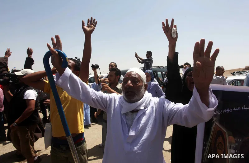 Egyptians Anti-Mubarak protester holding poster depicting youth killed during the uprising, reacts after a court sentenced deposed president Hosni Mubarak to life in prison, outside the police academy in Cairo, Egypt, 02...
