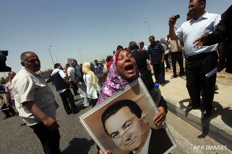 Supporters of deposed president Hosni Mubarak react after a court sentenced him to life in prison, outside the police academy where the court is located in Cairo June 2, 2012. Mubarak was sentenced to life in prison on S...