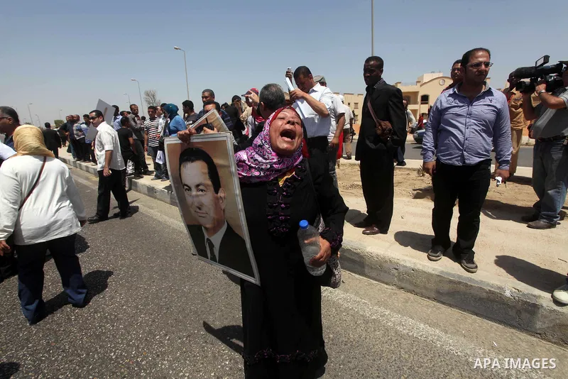 Supporters of deposed president Hosni Mubarak react after a court sentenced him to life in prison, outside the police academy where the court is located in Cairo June 2, 2012. Mubarak was sentenced to life in prison on S...