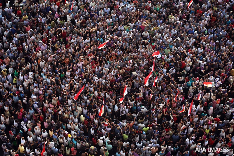 A view taken from a building overviewing Tahrir square shows Egyptian protesters shouting slogans against former President Hosni Mubarak and his aides during a demonstration hours after the announcement of the verdict in...