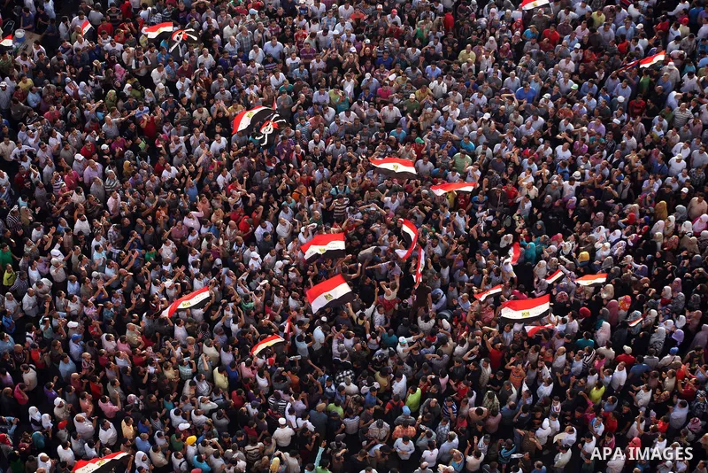 A view taken from a building overviewing Tahrir square shows Egyptian protesters shouting slogans against former President Hosni Mubarak and his aides during a demonstration hours after the announcement of the verdict in...