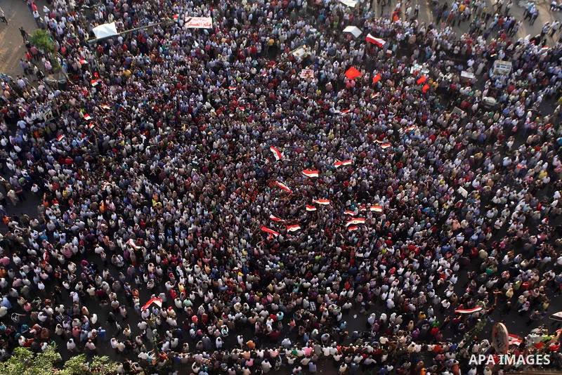 A view taken from a building overviewing Tahrir square shows Egyptian protesters shouting slogans against former President Hosni Mubarak and his aides during a demonstration hours after the announcement of the verdict in...