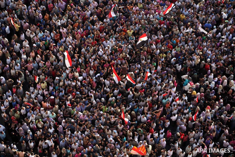 A view taken from a building overviewing Tahrir square shows Egyptian protesters shouting slogans against former President Hosni Mubarak and his aides during a demonstration hours after the announcement of the verdict in...