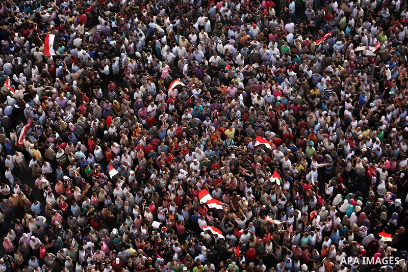 A view taken from a building overviewing Tahrir square shows Egyptian protesters shouting slogans against former President Hosni Mubarak and his aides during a demonstration hours after the announcement of the verdict in...